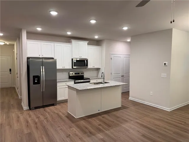 a view of kitchen with stainless steel appliances a refrigerator and a stove top oven