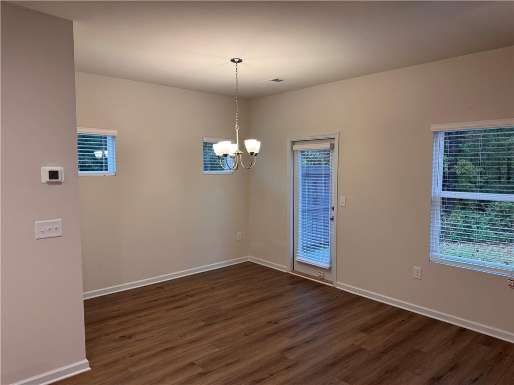 11 Huntley Trace Hoschton, GA 30548 - Photo 4 of 12 a view of an empty room with wooden floor and a window