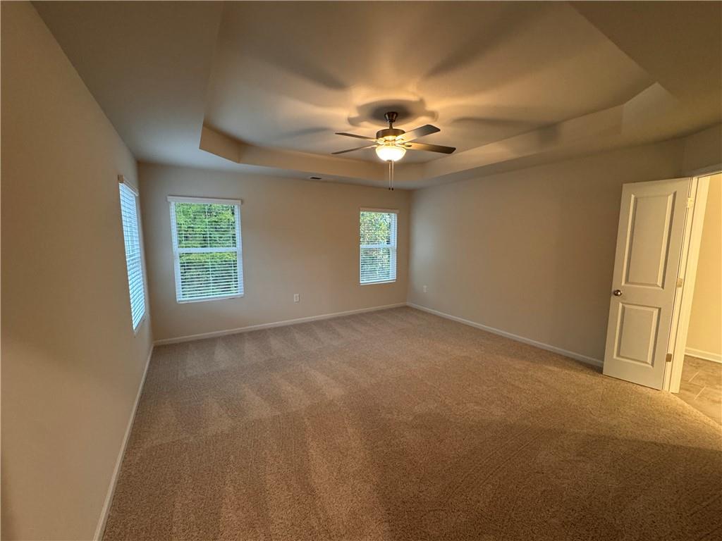 11 Huntley Trace Hoschton, GA 30548 - Photo 5 of 12 an empty room with windows and chandelier fan