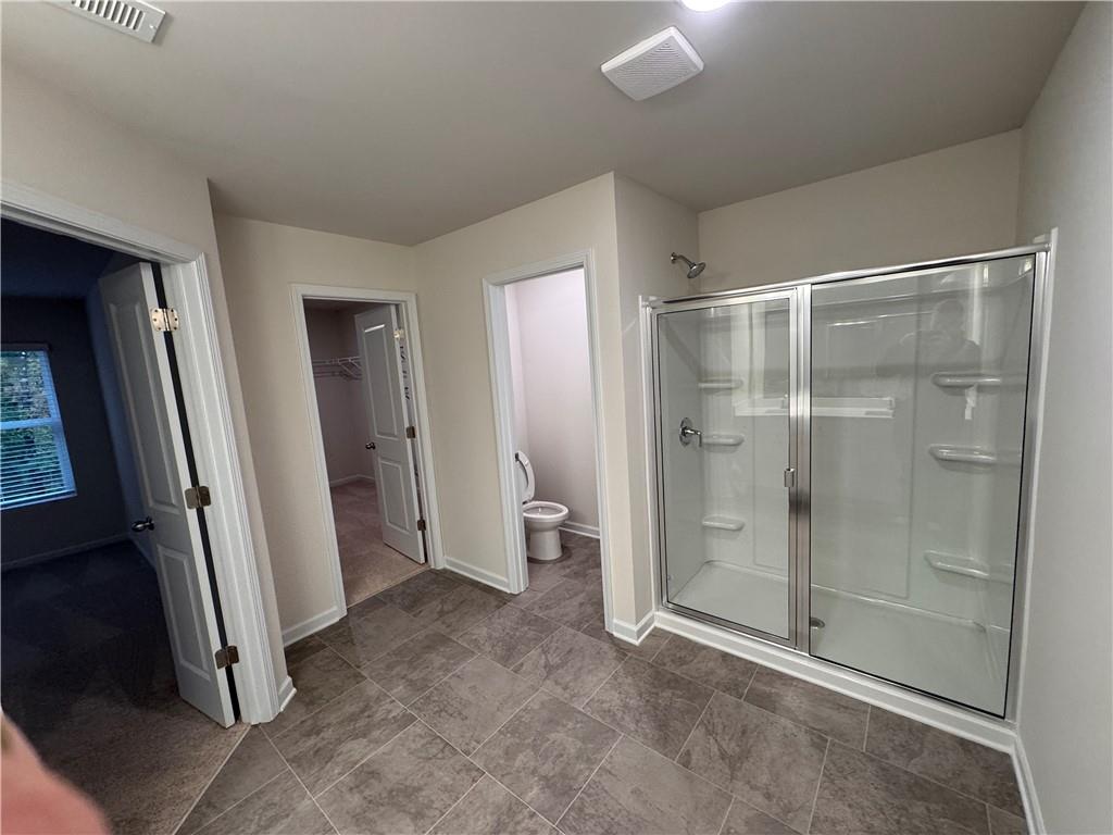11 Huntley Trace Hoschton, GA 30548 - Photo 6 of 12 a bathroom with a shower and a glass door