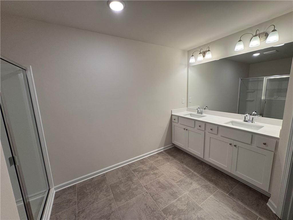 11 Huntley Trace Hoschton, GA 30548 - Photo 7 of 12 a bathroom with a double vanity sink and mirror