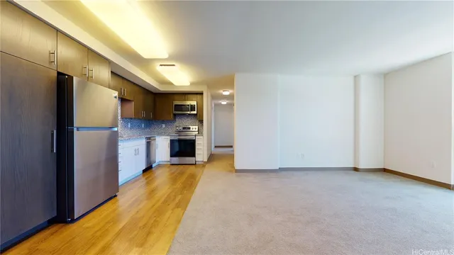 a view of a kitchen with a refrigerator a stove top oven and cabinets