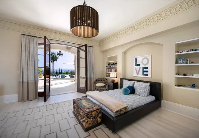 a bedroom with a bed and a chandelier