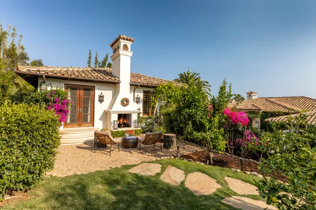a front view of a house with a yard and a fountain