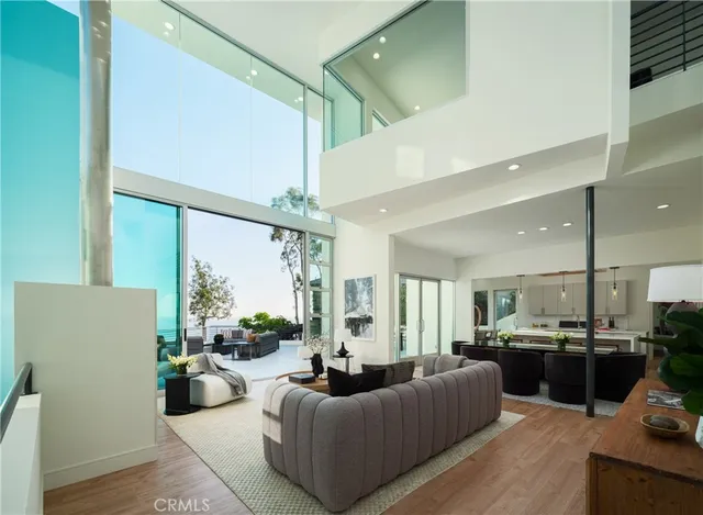 a living room with furniture kitchen view and a large window