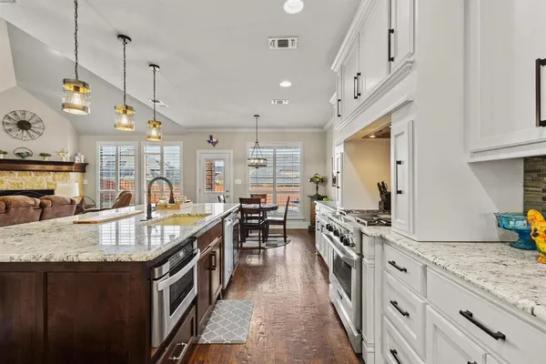 a kitchen with stainless steel appliances granite countertop a sink stove and refrigerator