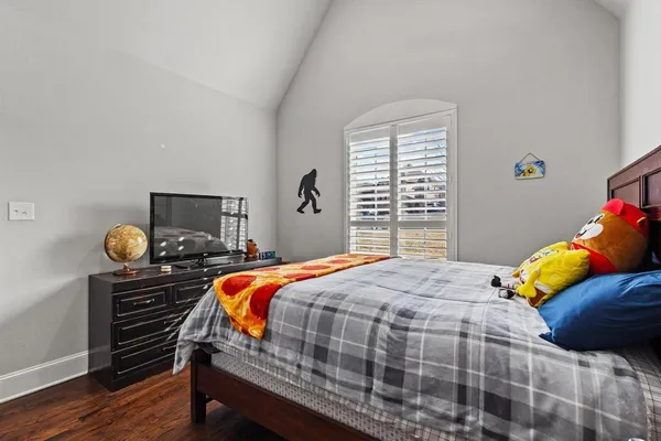 a bedroom with a bed and wooden floor