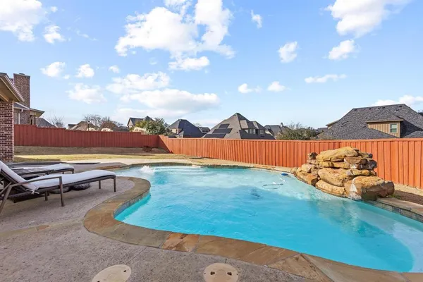 a view of a swimming pool with a lounge chair and a fire pit