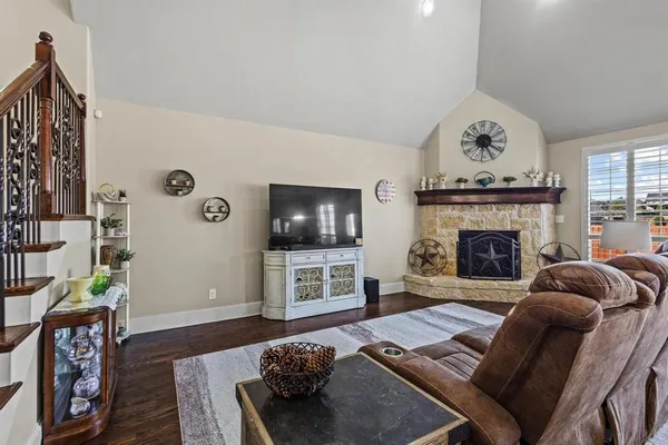 a living room with furniture a flat screen tv and a fireplace