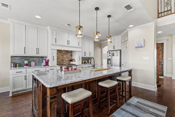 a kitchen with stainless steel appliances granite countertop a kitchen island a stove a table and chairs in it