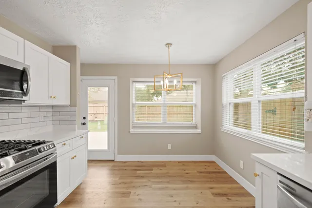 a kitchen with stainless steel appliances granite countertop a stove a sink and a wooden floors
