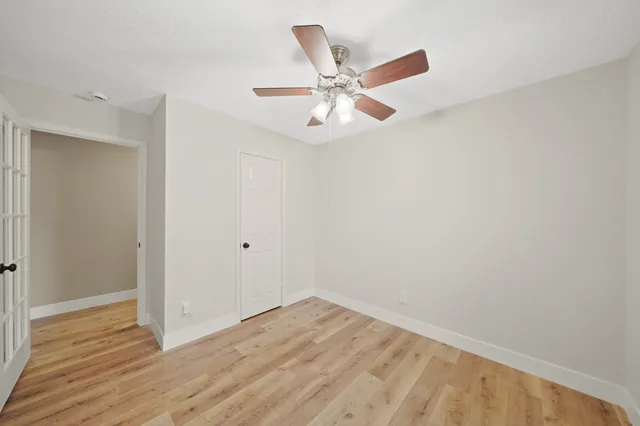 a view of a room with wooden floor and white walls