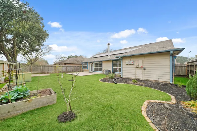 a view of a house with backyard sitting area and garden