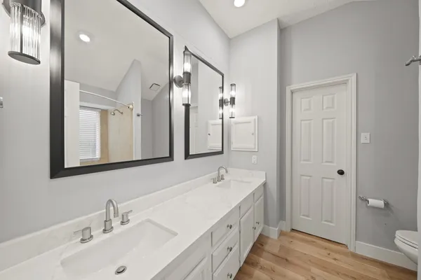 a bathroom with a double vanity sink mirror and shower