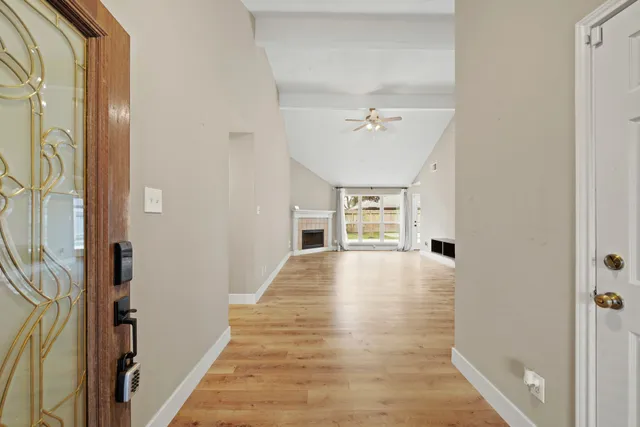a view of empty room with wooden floor and fan