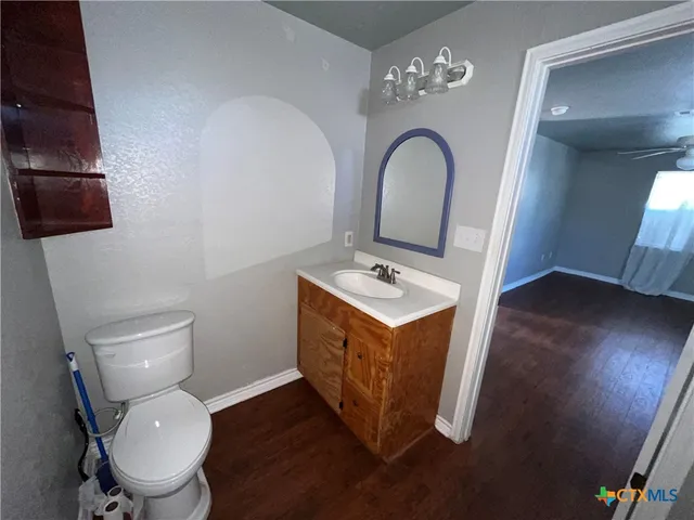 a bathroom with a toilet sink and mirror