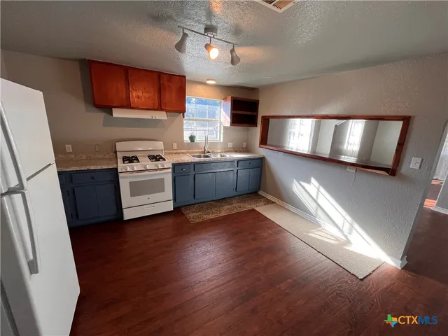 a kitchen with stainless steel appliances granite countertop a stove sink and cabinets