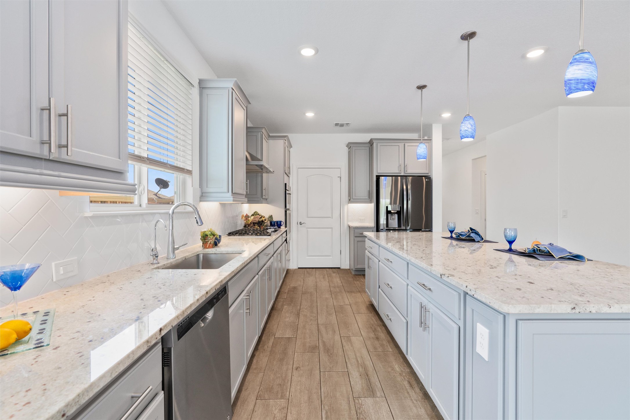 202 Spanish Star Street Georgetown, TX 78633 - Photo 10 of 32 a large kitchen with kitchen island granite countertop a sink a counter top space stainless steel appliances and cabinets