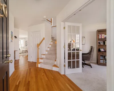 a view of a bedroom with wooden floor and stairs