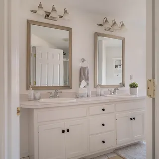 a bathroom with double sink and a mirror