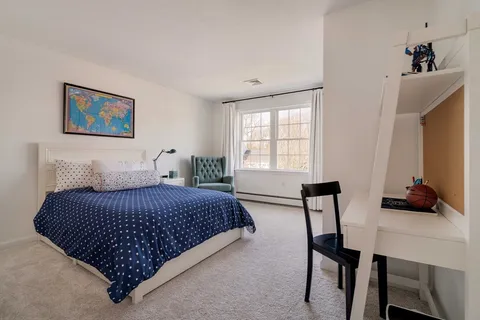 a bedroom with a bed a table and chair