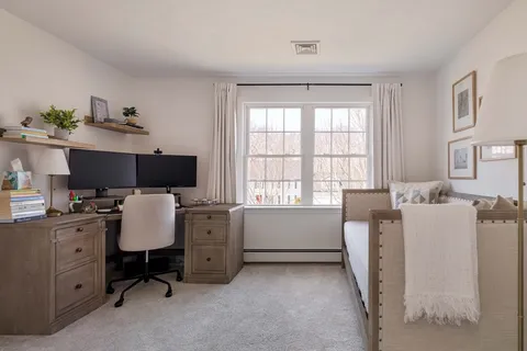 a view of a workspace with furniture and a window