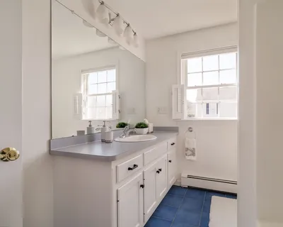 a bathroom with a sink a mirror and a window