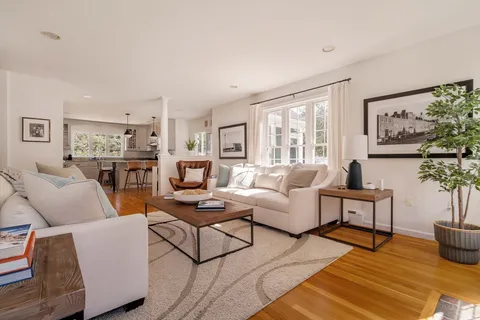 a living room with furniture kitchen view and a window