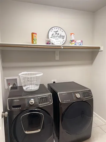 a view of an empty room with wooden floor and fan