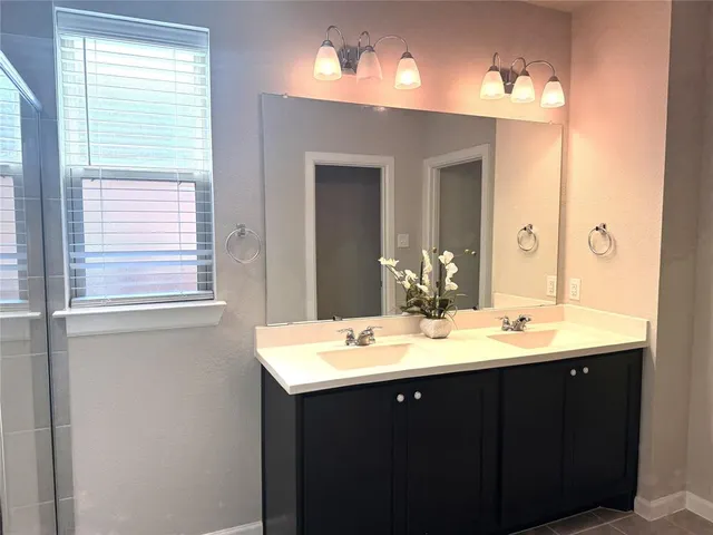 a bathroom with a shower sink and mirror