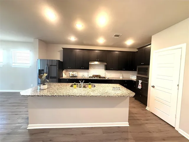 a view of a room with kitchen countertops and wooden floor