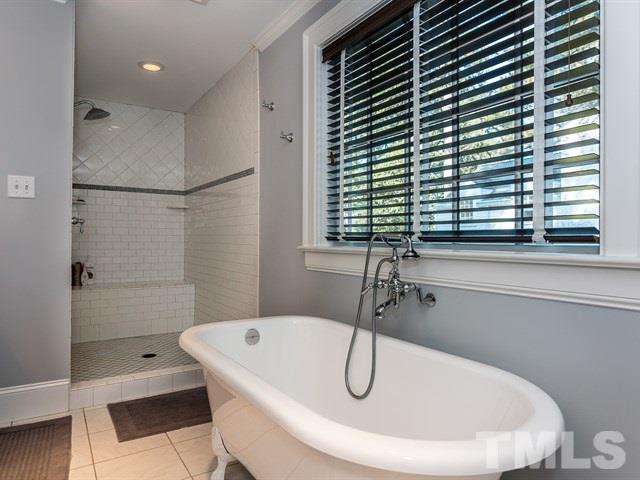 1506 Pineview Street Raleigh, NC 27608 - Photo 17 of 25 a bathroom with a white bath tub sitting next to a window