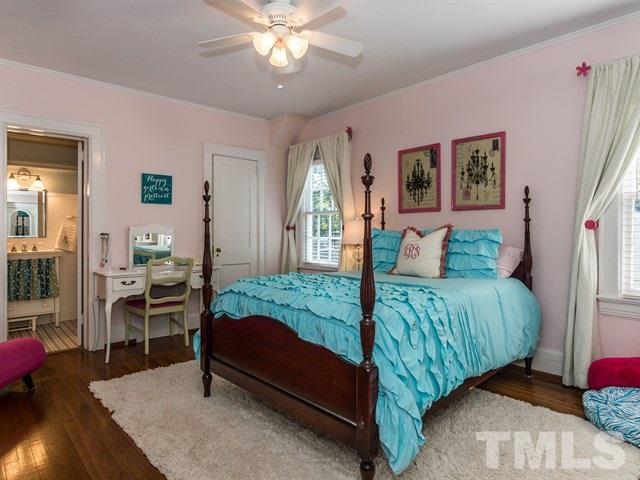 1506 Pineview Street Raleigh, NC 27608 - Photo 18 of 25 a bedroom with a bed and a chandelier