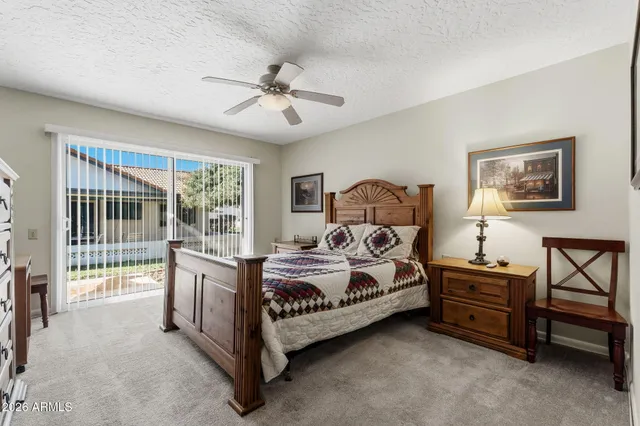 a bedroom with a bed window and a flat tv screen