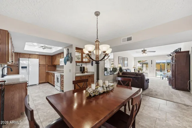a view of a dining room and livingroom with furniture wooden floor a chandelier
