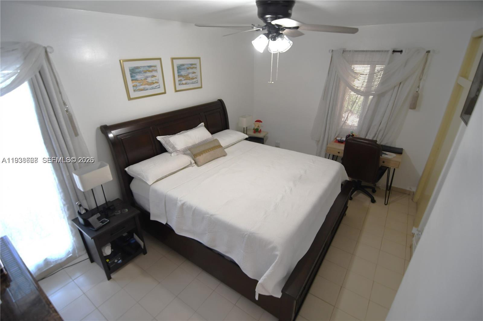 1014 West 68th Street Hialeah, FL 33014 - Photo 13 of 40 a bedroom with a bed and a chandelier