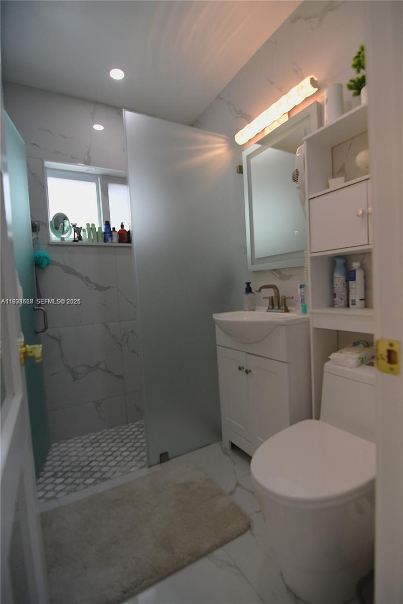 1014 West 68th Street Hialeah, FL 33014 - Photo 15 of 40 a bathroom with a sink a toilet and mirror