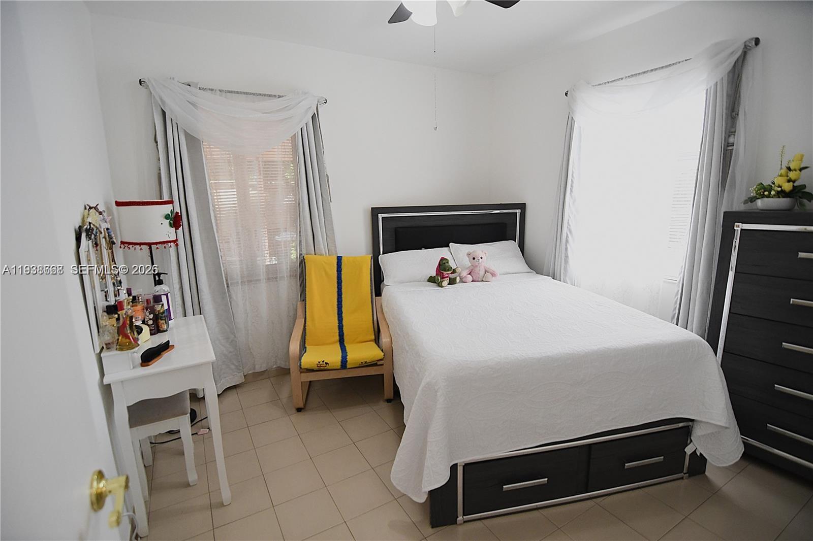 1014 West 68th Street Hialeah, FL 33014 - Photo 18 of 40 a bed room with a bed and a chair