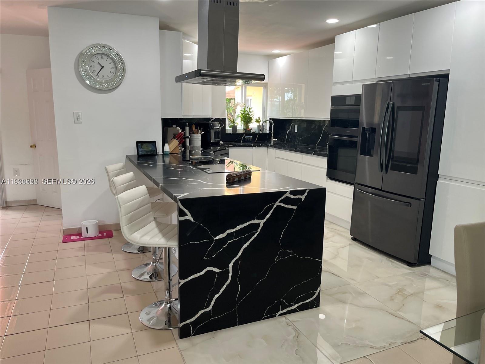 1014 West 68th Street Hialeah, FL 33014 - Photo 26 of 40 a kitchen with stainless steel appliances a stove a refrigerator a dining table and chairs