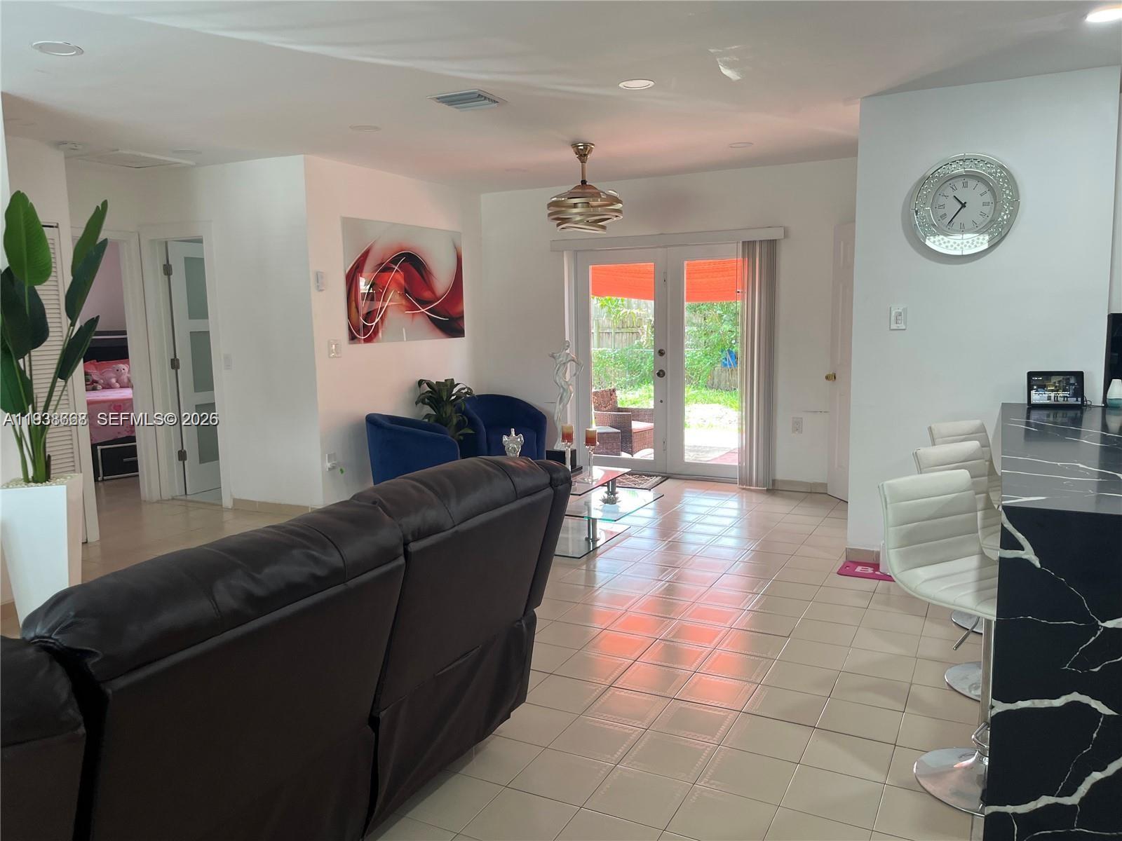 1014 West 68th Street Hialeah, FL 33014 - Photo 28 of 40 a living room with furniture and a flat screen tv