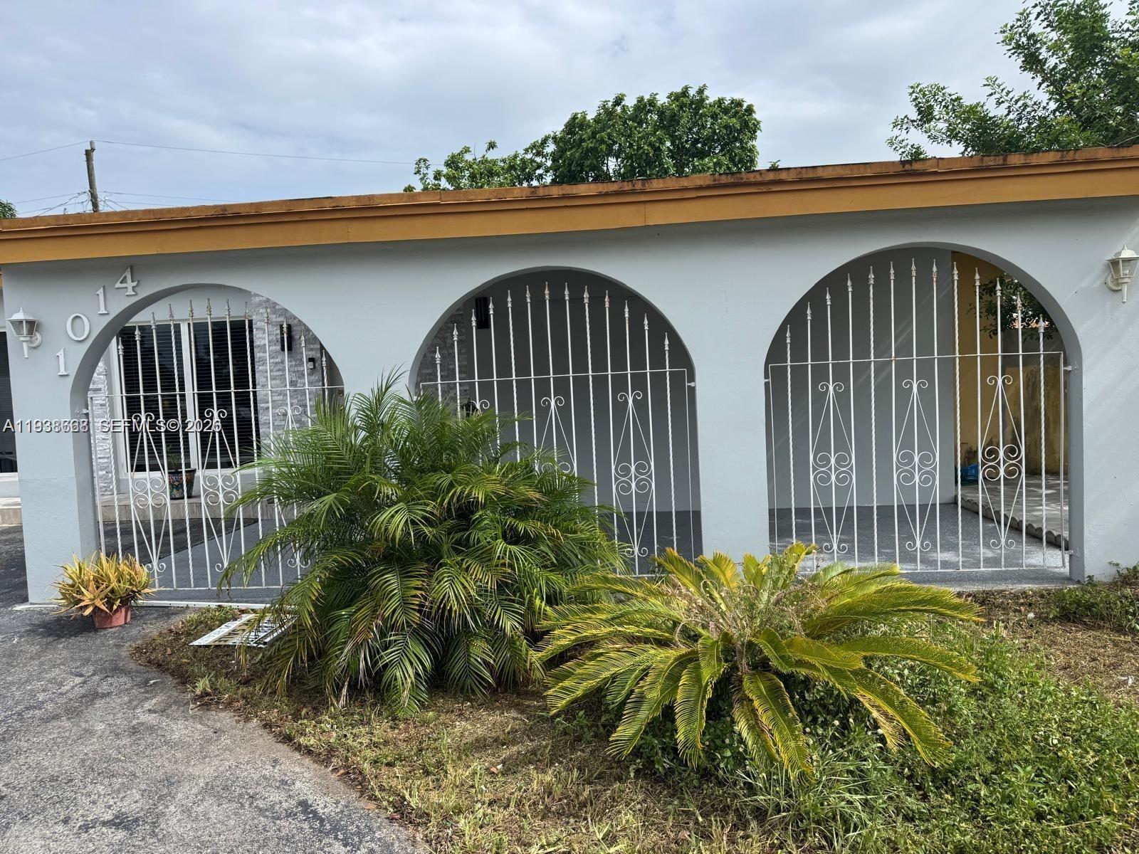 1014 West 68th Street Hialeah, FL 33014 - Photo 3 of 40 a front view of a house with garden