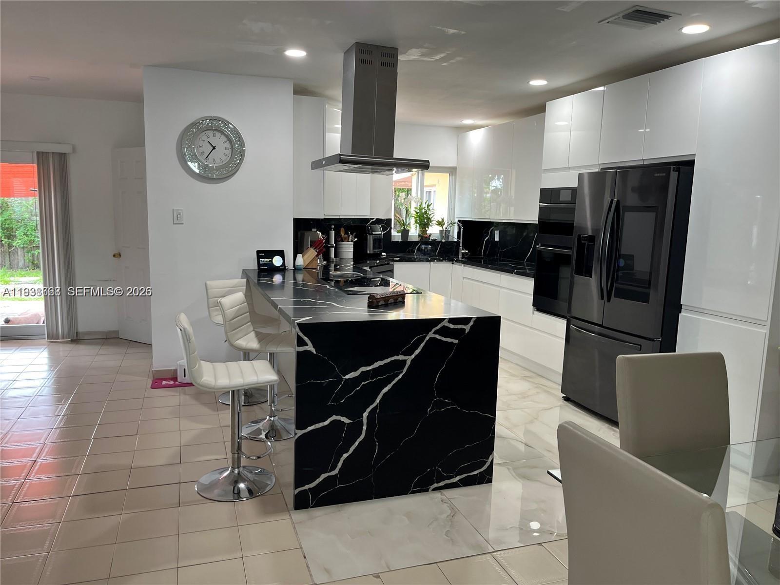 1014 West 68th Street Hialeah, FL 33014 - Photo 4 of 40 a large kitchen with a table and chairs