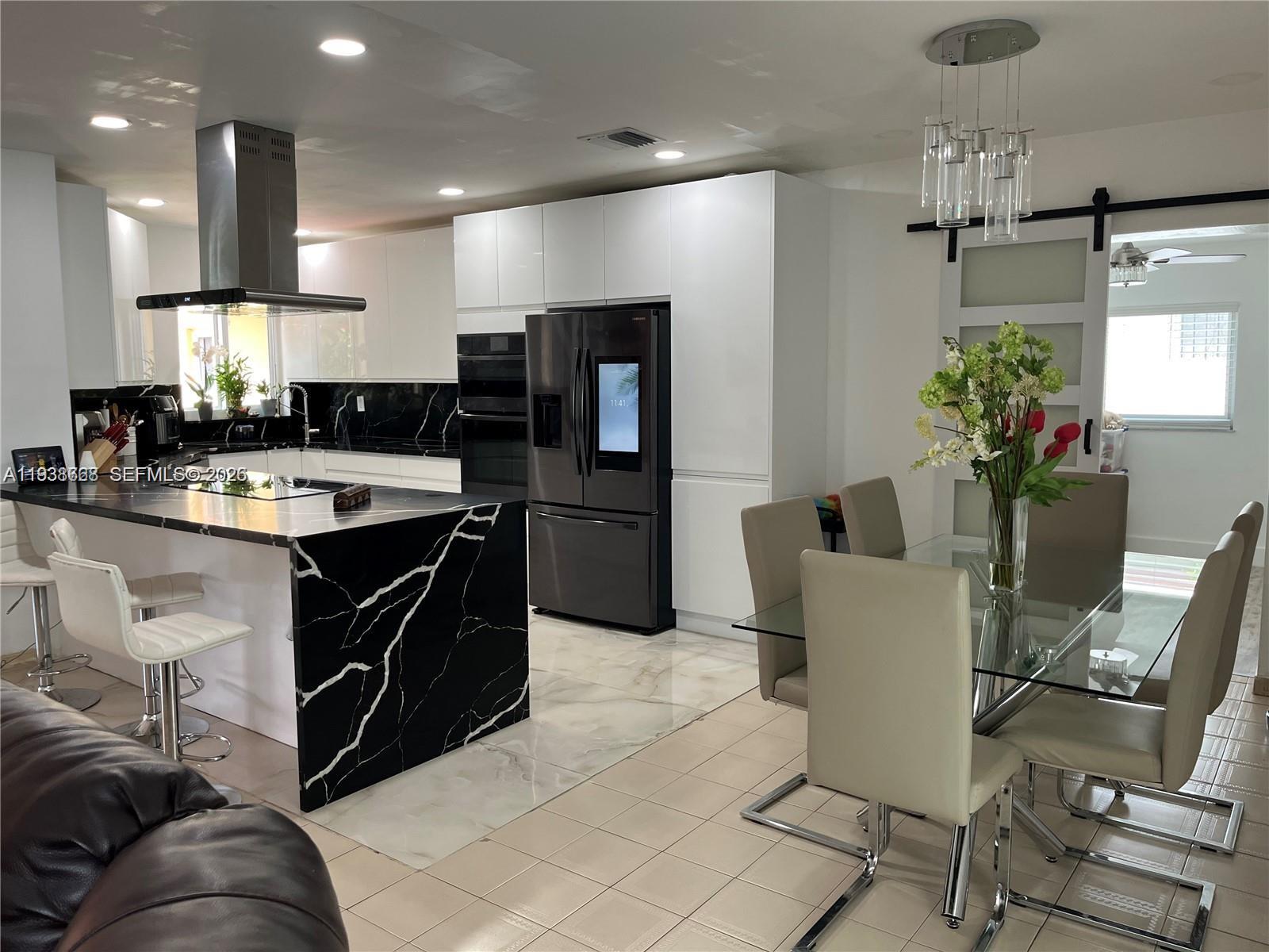 1014 West 68th Street Hialeah, FL 33014 - Photo 7 of 40 a kitchen with a table and chairs