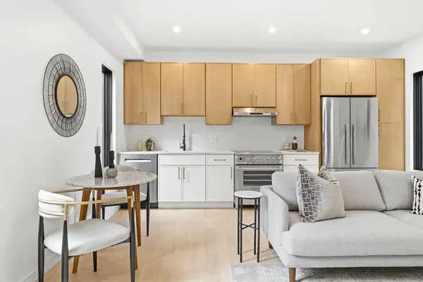 a kitchen with a refrigerator a stove a dining table and chairs