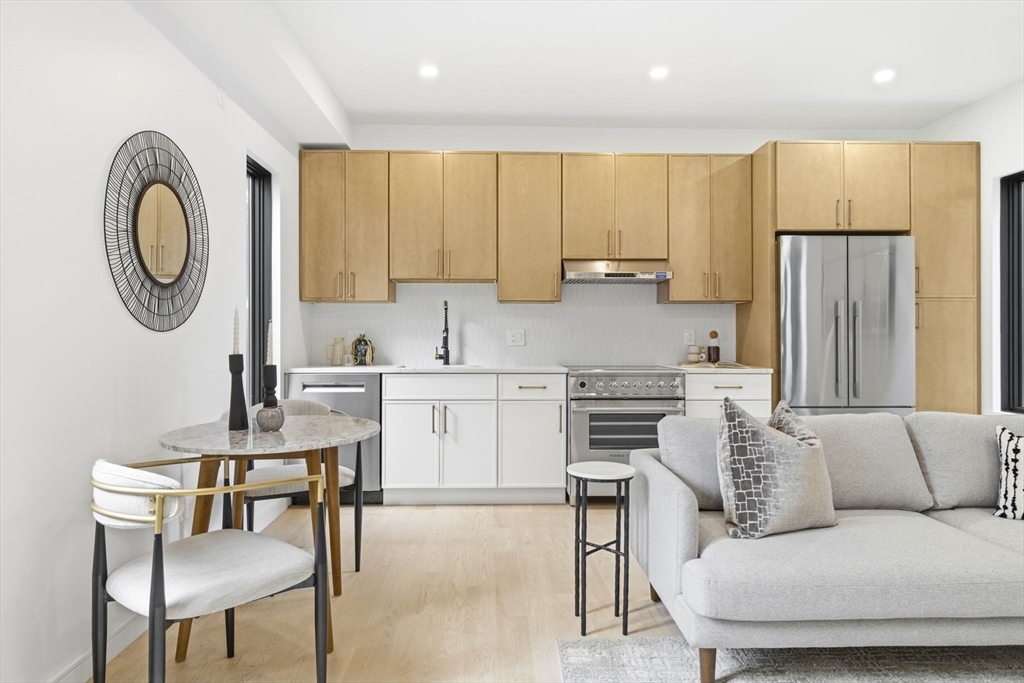 a kitchen with a refrigerator a stove a dining table and chairs