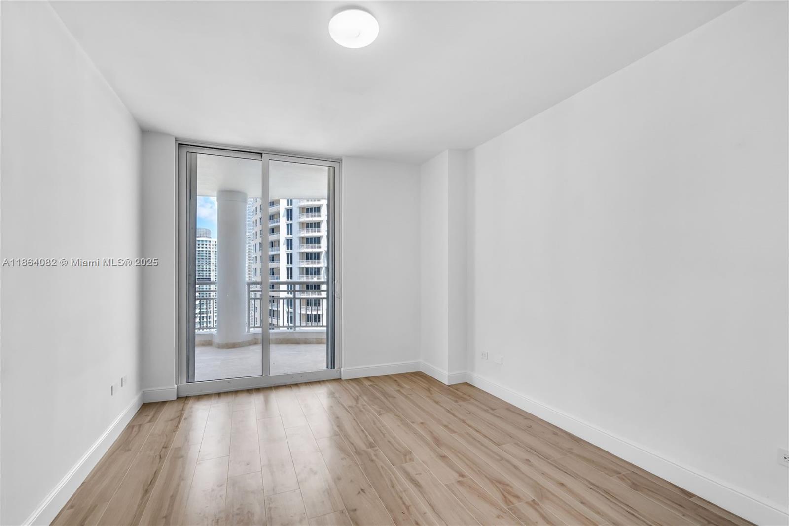 808 Brickell Key Drive, Unit 3205 Miami, FL 33131 - Photo 17 of 51 a view of an empty room with wooden floor and a window
