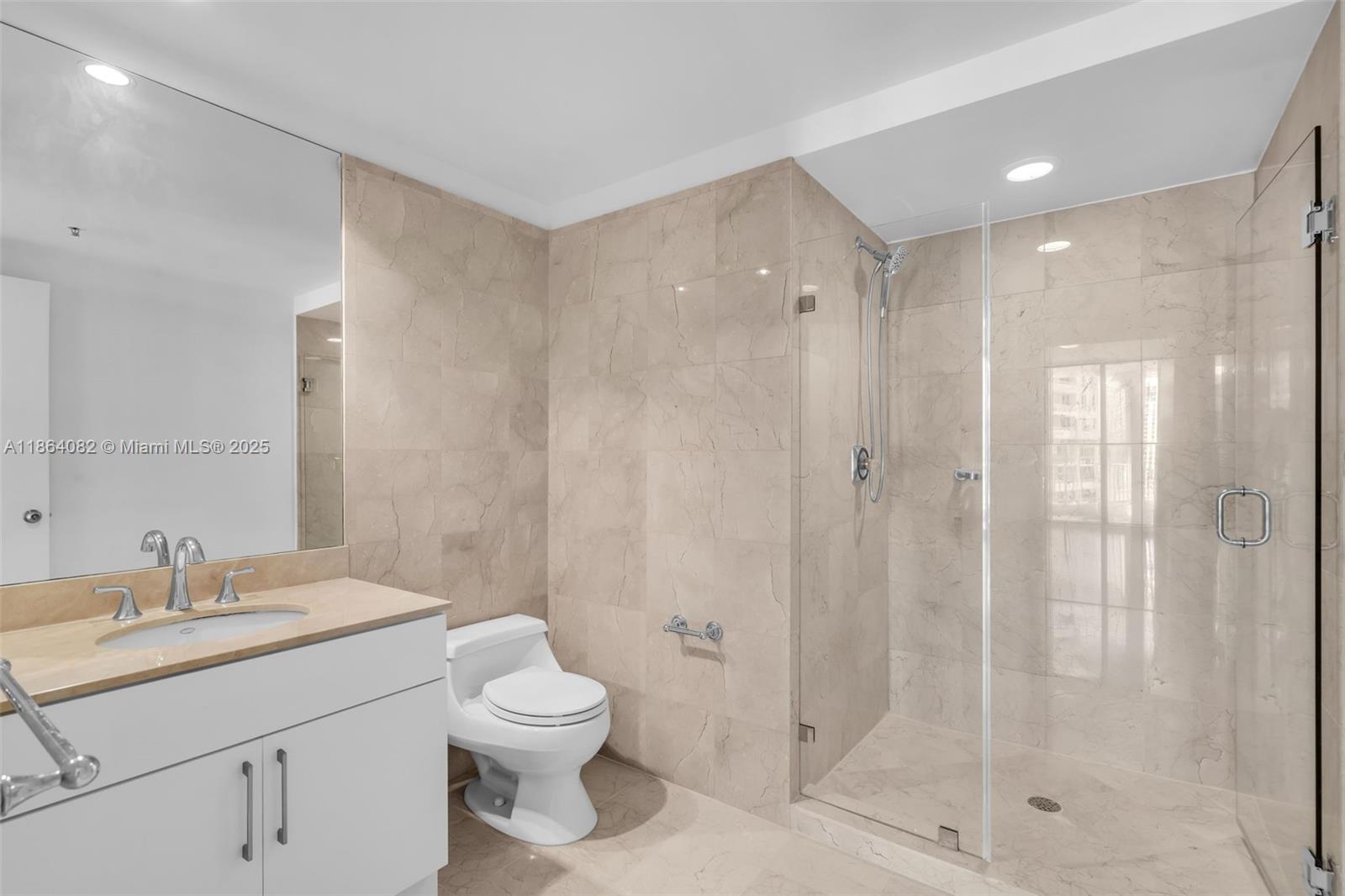 808 Brickell Key Drive, Unit 3205 Miami, FL 33131 - Photo 20 of 51 a bathroom with a shower sink vanity mirror and toilet