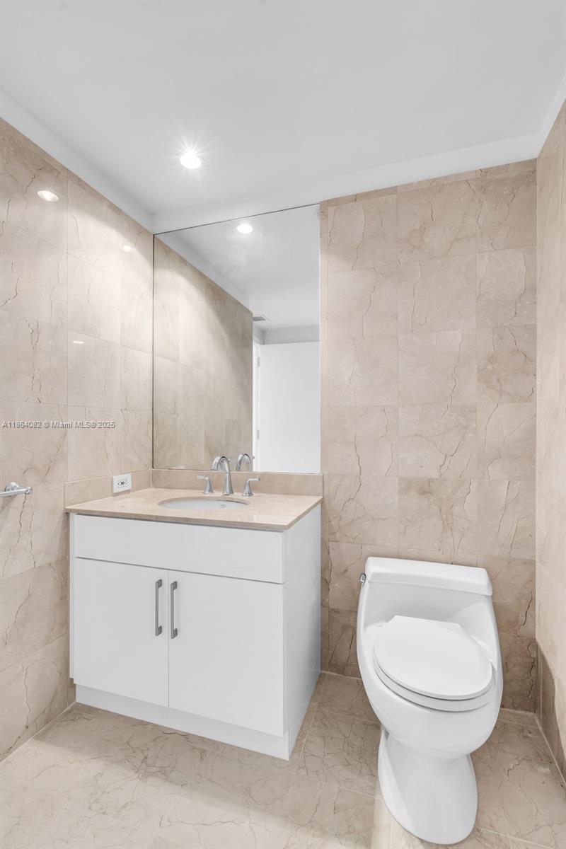 808 Brickell Key Drive, Unit 3205 Miami, FL 33131 - Photo 21 of 51 a bathroom with a toilet a sink and mirror