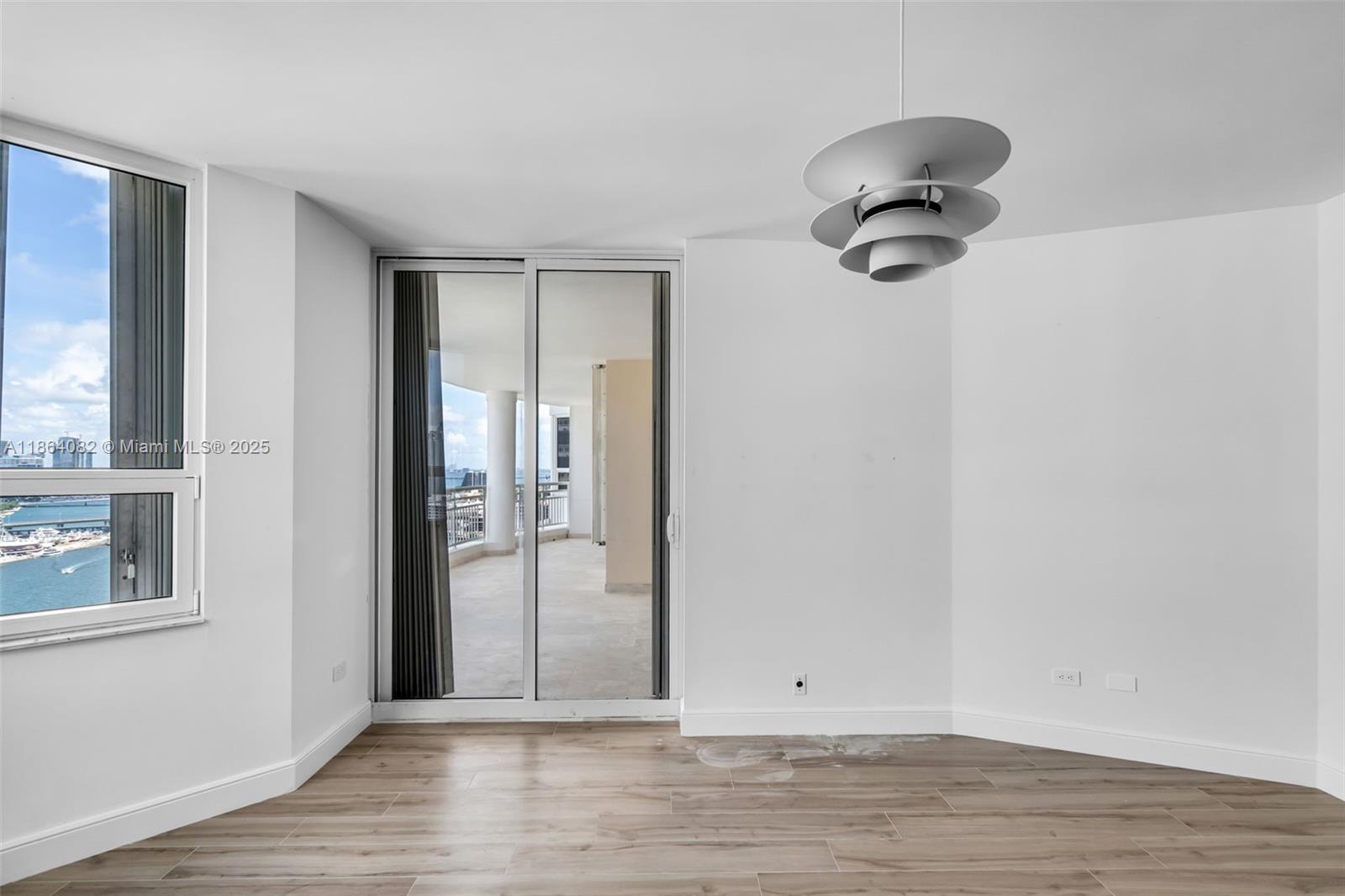 808 Brickell Key Drive, Unit 3205 Miami, FL 33131 - Photo 27 of 51 an empty room with wooden floor and windows