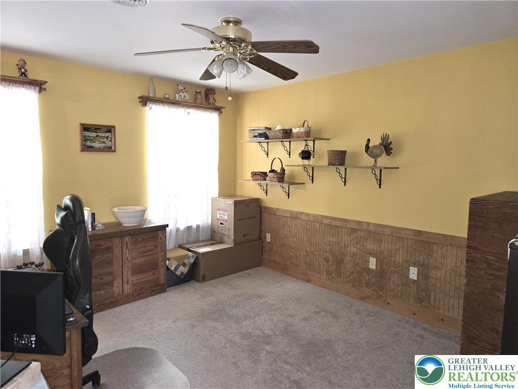 477 Quiet Valley Road Mount Bethel, PA 18343 - Photo 31 of 53 A well-lit room featuring wainscoting and a ceiling fan, offering a versatile space for an office or study.